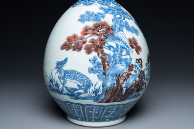 A Chinese blue, white and copper-red bottle vase with a deer and birds among blossoming branches, Daoguang