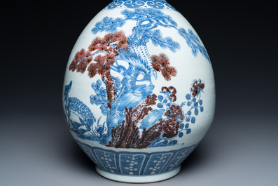 A Chinese blue, white and copper-red bottle vase with a deer and birds among blossoming branches, Daoguang
