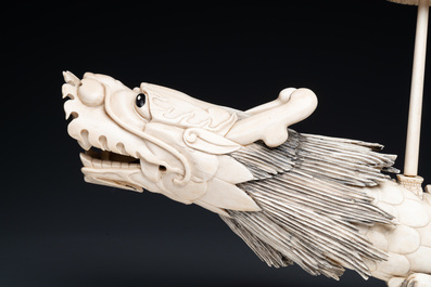 A Chinese carved ivory dragon boat on wooden stand, 19th C.