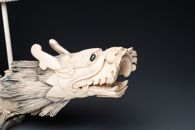 A Chinese carved ivory dragon boat on wooden stand, 19th C.