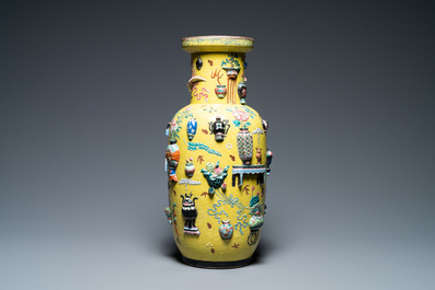 Een Chinese famille rose rouleau vaas met reli&euml;fdecor van antiquiteiten op gele fondkleur, 19e eeuw
