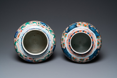 A pair of Chinese wucai 'galloping horses' vases and covers, Transitional period