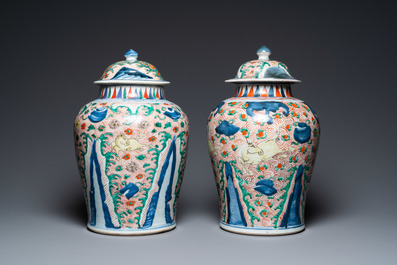 A pair of Chinese wucai 'galloping horses' vases and covers, Transitional period