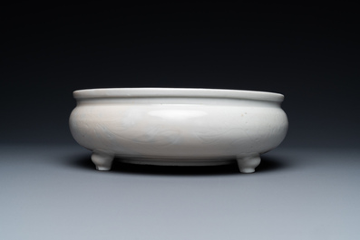 Un br&ucirc;le-parfum tripod &agrave; d&eacute;cor floral incis&eacute; en porcelaine blanc de Chine de Dehua sur socle en bois, Kangxi