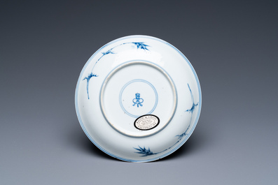 Een Chinees blauw-wit en koperrood bord met floraal decor, Kangxi