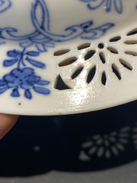 A pair of Chinese blue and white reticulated double-walled cups and saucers, Kangxi