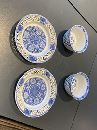 A pair of Chinese blue and white reticulated double-walled cups and saucers, Kangxi