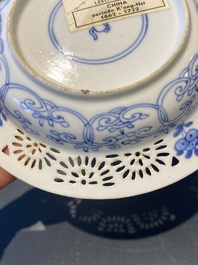 A pair of Chinese blue and white reticulated double-walled cups and saucers, Kangxi