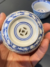 A pair of Chinese blue and white reticulated double-walled cups and saucers, Kangxi