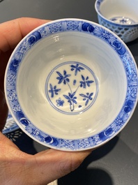 A pair of Chinese blue and white reticulated double-walled cups and saucers, Kangxi