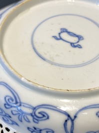 A pair of Chinese blue and white reticulated double-walled cups and saucers, Kangxi