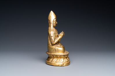 A Sino-Tibetan gilt bronze figure of a lamaic official or dignitary, probably 16th C.