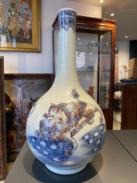 A Chinese blue, white and copper-red bottle vase with Buddhist lions, 20th C.