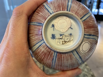 A pair of Chinese blue, white and copper-red 'lotus' bowls, Kangxi mark, 19th C.