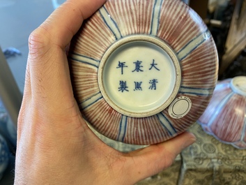 A pair of Chinese blue, white and copper-red 'lotus' bowls, Kangxi mark, 19th C.
