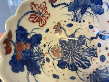 A pair of Chinese blue, white and copper-red 'lotus' bowls, Kangxi mark, 19th C.