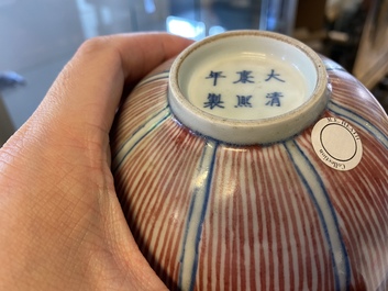 A pair of Chinese blue, white and copper-red 'lotus' bowls, Kangxi mark, 19th C.