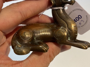 Two Chinese bronze scroll weights and a seal stamp, Qing