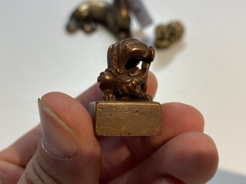 Two Chinese bronze scroll weights and a seal stamp, Qing