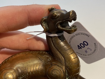 Two Chinese bronze scroll weights and a seal stamp, Qing