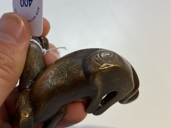 Two Chinese bronze scroll weights and a seal stamp, Qing