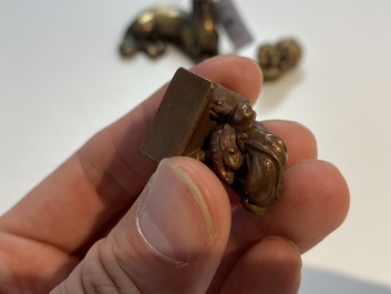 Two Chinese bronze scroll weights and a seal stamp, Qing