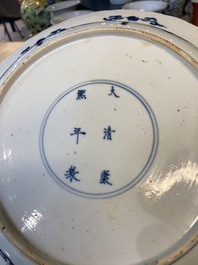A Chinese blue and white dish with two ladies and two rabbits in a garden, Kangxi mark and of the period