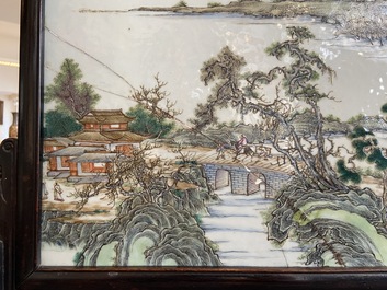 A Chinese rectangular famille rose 'landscape' plaque mounted in a wooden table screen, 19/20th C.