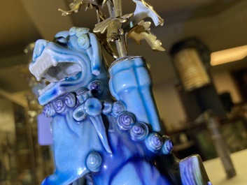 Une paire de lions bouddhistes en porcelaine de Chine en turquoise et aubergine mont&eacute;s comme cand&eacute;labres en bronze dor&eacute;, Kangxi et 19&egrave;me