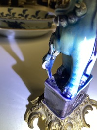 Une paire de lions bouddhistes en porcelaine de Chine en turquoise et aubergine mont&eacute;s comme cand&eacute;labres en bronze dor&eacute;, Kangxi et 19&egrave;me