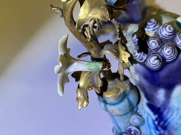Une paire de lions bouddhistes en porcelaine de Chine en turquoise et aubergine mont&eacute;s comme cand&eacute;labres en bronze dor&eacute;, Kangxi et 19&egrave;me