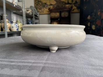 Un br&ucirc;le-parfum tripod &agrave; d&eacute;cor floral incis&eacute; en porcelaine blanc de Chine de Dehua sur socle en bois, Kangxi