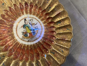 Een gelobde Chinese vergulde famille rose 'lotus' kop en schotel en &eacute;&eacute;n met hanen, Yongzheng/Qianlong