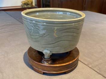 Een Chinese Longquan celadon driepotige wierookbrander met kintsugi herstelling op houten sokkel, Ming