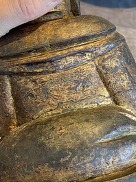 Een Chinese vergulde bronzen Boeddha zittend op een rots, Ming