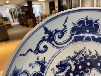 A Chinese blue and white 'dragon' dish and three iron-red and famille rose plates, 18th C.