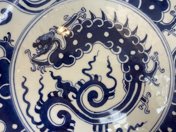 A Chinese blue and white 'dragon' dish and three iron-red and famille rose plates, 18th C.