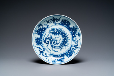 A Chinese blue and white 'dragon' dish and three iron-red and famille rose plates, 18th C.