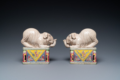 A pair of Chinese famille rose elephants on stands, 20th C.