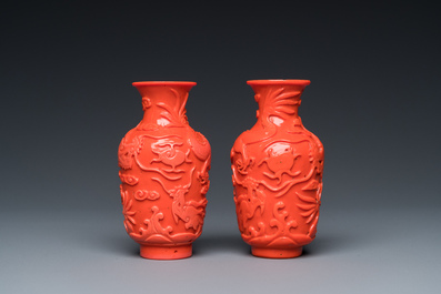 Een zeldzaam paar Chinese pseudo-koraal vaasjes in Peking glas op houten sokkels, 19/20e eeuw