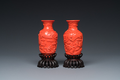Een zeldzaam paar Chinese pseudo-koraal vaasjes in Peking glas op houten sokkels, 19/20e eeuw