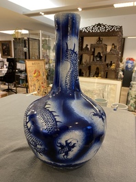 A Chinese blue and white 'dragons' bottle vase, 19th C.