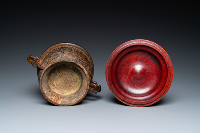 Een Chinese bronzen archa&iuml;sche wierookbrander met later houten deksel, Ming