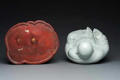 A Chinese blanc de Chine Buddha on lacquered and gilded wooden 'lotus' stand, Qianlong/Jiaqing