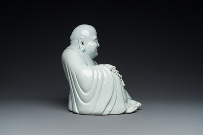 A Chinese blanc de Chine Buddha on lacquered and gilded wooden 'lotus' stand, Qianlong/Jiaqing