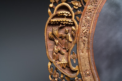 An oval Chinese reticulated gilded wooden mirror, 19/20th C.