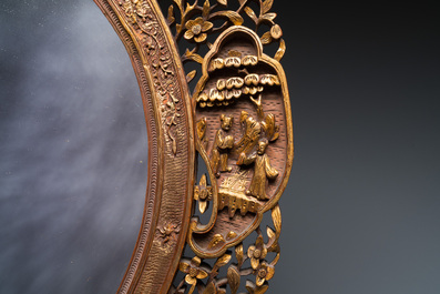 An oval Chinese reticulated gilded wooden mirror, 19/20th C.