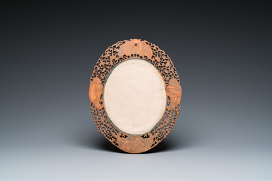 An oval Chinese reticulated gilded wooden mirror, 19/20th C.