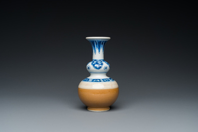 A Chinese blue and white double gourd vase with caf&eacute; au lait-ground base, Kangxi