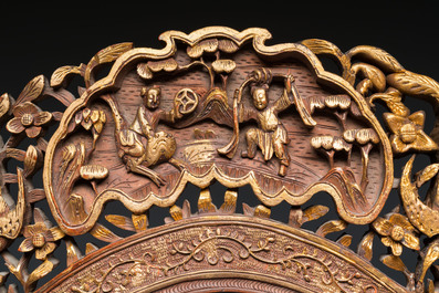 An oval Chinese reticulated gilded wooden mirror, 19/20th C.